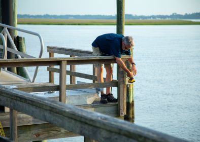 Smart Sea Level Sensors program co-founder Russell Clark installs a sea level sensor on a dock in Savannah, Georgia
