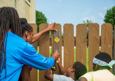 ISeeChange ambassador Yasmin Davis gets some help from students and teachers to install a rain gauge at a community center in New Orleans, Louisiana